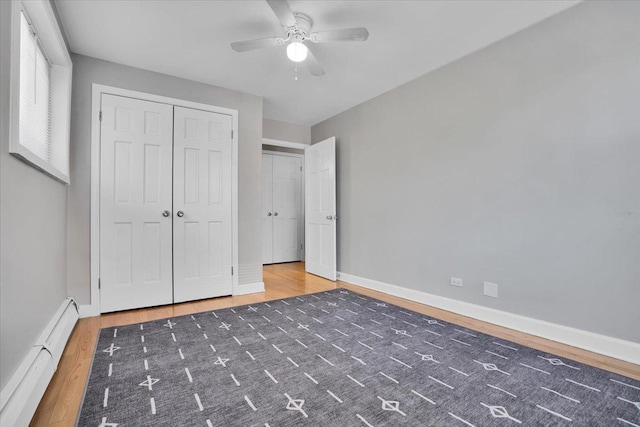 2907 W Summerdale Ave Unit D2, Chicago, IL 60625 - unfurnished bedroom featuring a baseboard radiator, wood finished floors, baseboards, a closet, and a ceiling fan