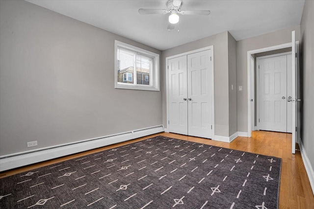 2907 W Summerdale Ave Unit D2, Chicago, IL 60625 - unfurnished bedroom featuring a baseboard radiator, wood finished floors, a closet, baseboards, and a ceiling fan