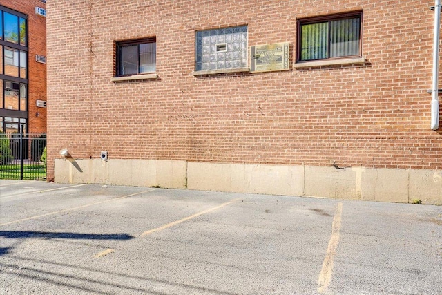 2907 W Summerdale Ave Unit D2, Chicago, IL 60625 - view of side of property featuring brick siding, fence, and uncovered parking