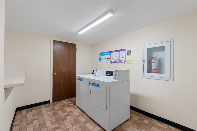shared laundry featuring separate washer and dryer and baseboards