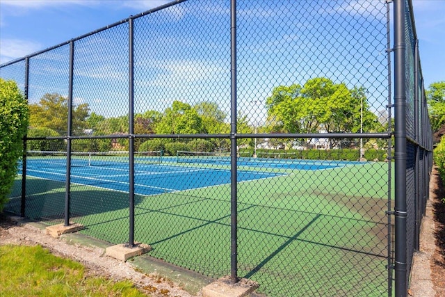 view of tennis court featuring fence