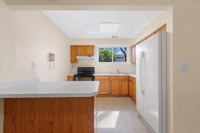 kitchen with freestanding refrigerator, under cabinet range hood, black range with electric cooktop, a sink, and a peninsula