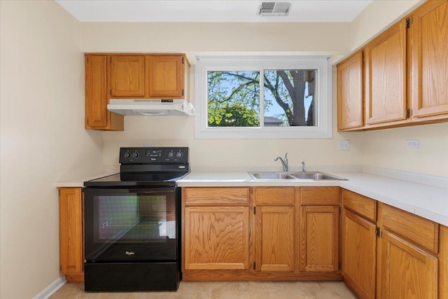 kitchen featuring under cabinet range hood, black electric range oven, a sink, light countertops, and brown cabinets