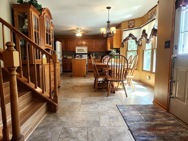 19629 Fiona Ave, Mokena, IL 60448 - dining area featuring a chandelier, stairway, ceiling fan, light stone finish floors, and baseboards
