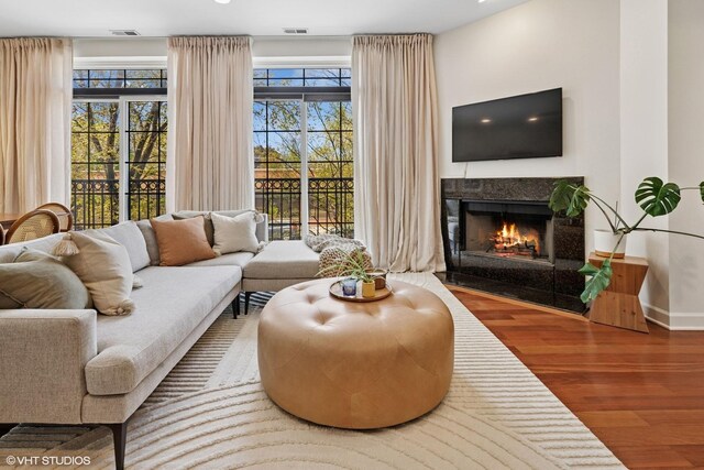 living room with wood finished floors, a fireplace, and baseboards
