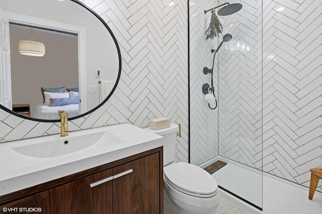 full bathroom with a shower stall, toilet, tile walls, vanity, and ensuite bath