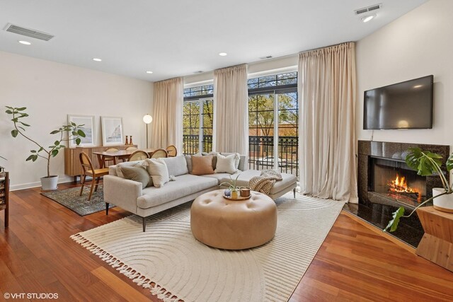 living room with a fireplace, wood finished floors, and recessed lighting
