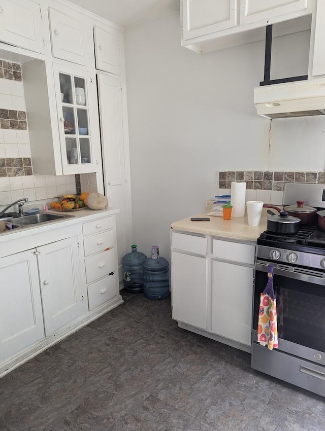 720 S Carroll Ave, Freeport, IL 61032 - kitchen featuring stainless steel gas range, a sink, decorative backsplash, under cabinet range hood, and white cabinetry