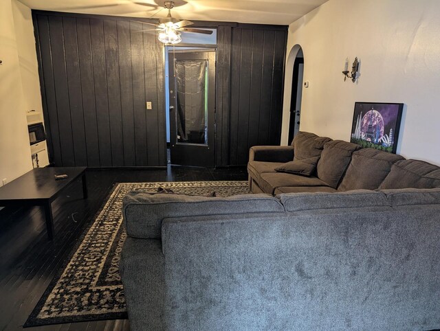 720 S Carroll Ave, Freeport, IL 61032 - living room with arched walkways, a ceiling fan, and wood walls