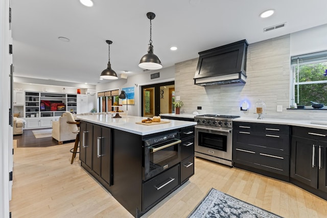 428 S Hillside Ave, Elmhurst, IL 60126 - kitchen with high end stainless steel range oven, dark cabinetry, custom exhaust hood, light countertops, and open floor plan