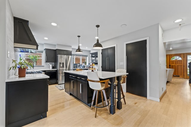 428 S Hillside Ave, Elmhurst, IL 60126 - kitchen featuring stainless steel refrigerator with ice dispenser, dark cabinetry, light countertops, custom range hood, and healthy amount of natural light