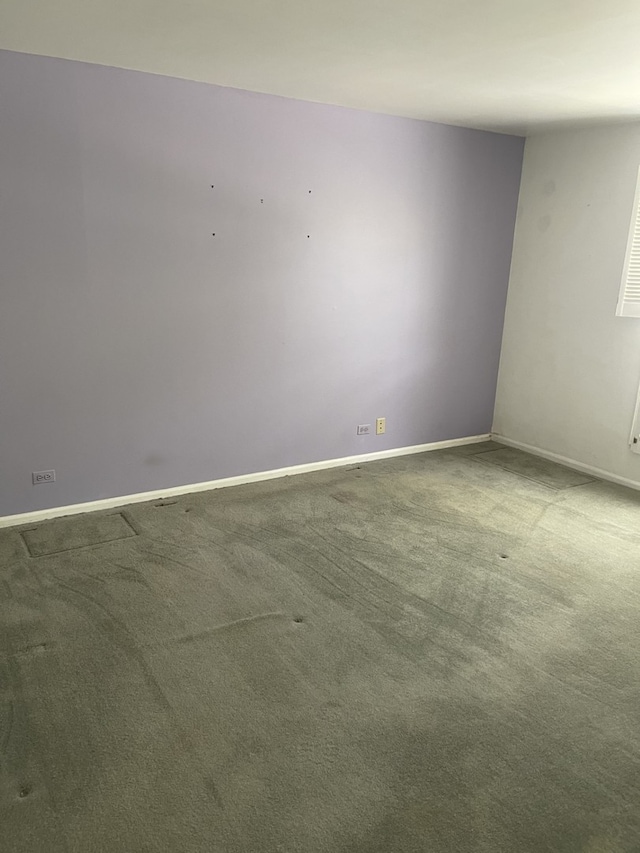carpeted spare room featuring baseboards