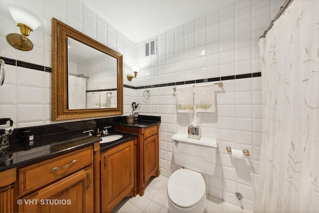 full bathroom with tile walls, toilet, a shower with shower curtain, vanity, and tile patterned floors