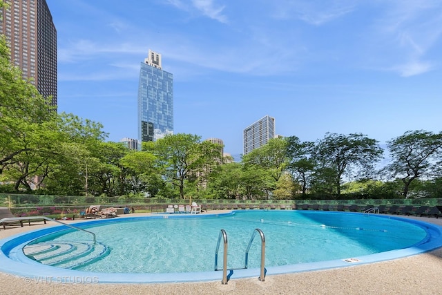 community pool with a view of city and fence
