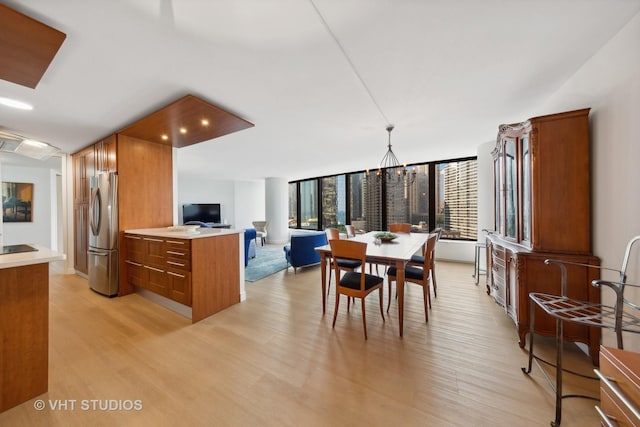 dining area featuring light wood-style flooring and a chandelier