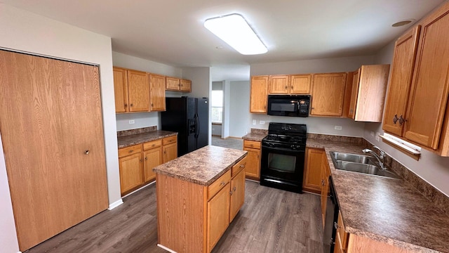 6409 Old Plank Blvd, Matteson, IL 60443 - kitchen with black appliances, a sink, a kitchen island, dark wood-type flooring, and dark countertops