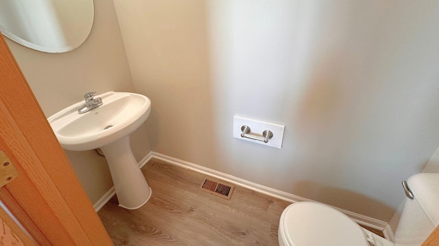 6409 Old Plank Blvd, Matteson, IL 60443 - half bathroom with toilet, wood finished floors, baseboards, and a sink