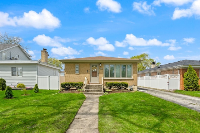 bungalow featuring brick siding and a gate