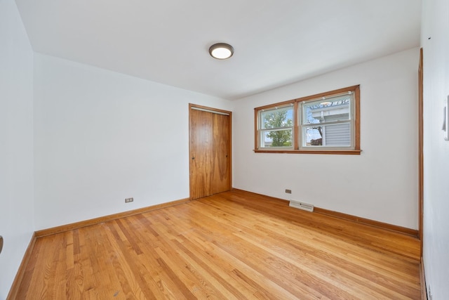 empty room featuring light wood-style flooring and baseboards