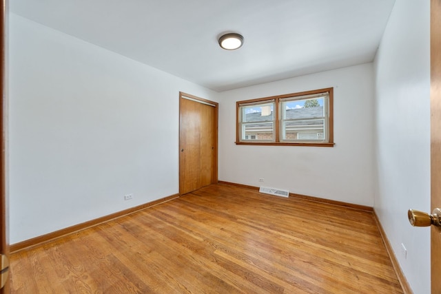 empty room featuring light wood finished floors and baseboards