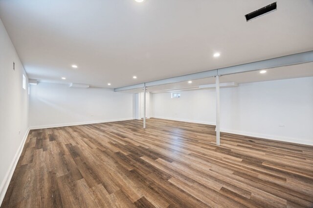 finished below grade area featuring wood finished floors, recessed lighting, and baseboards