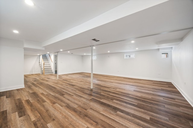 basement with stairway, recessed lighting, wood finished floors, and baseboards