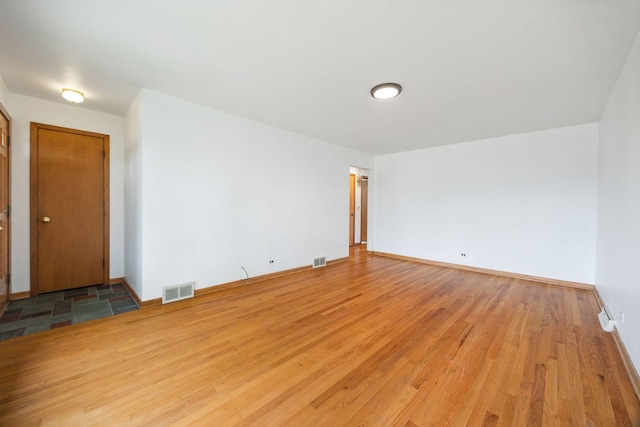 spare room with wood finished floors and baseboards