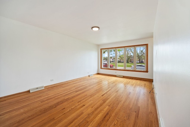 empty room with light wood-style floors and baseboards