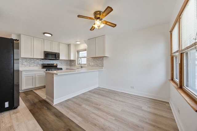 kitchen with appliances with stainless steel finishes, ceiling fan, backsplash, and light countertops