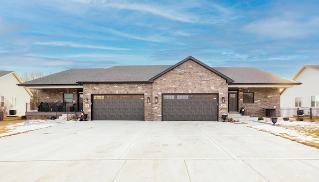 view of front of property featuring brick siding, an attached garage, concrete driveway, and roof with shingles