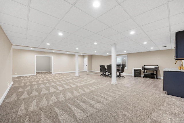 finished below grade area with light carpet, baseboards, recessed lighting, and a drop ceiling
