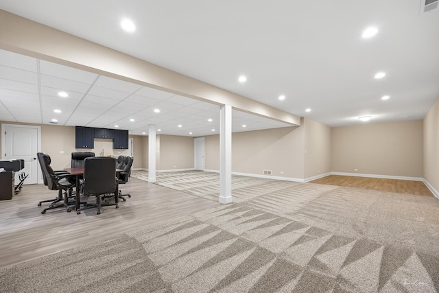 finished basement featuring light wood-style flooring and baseboards