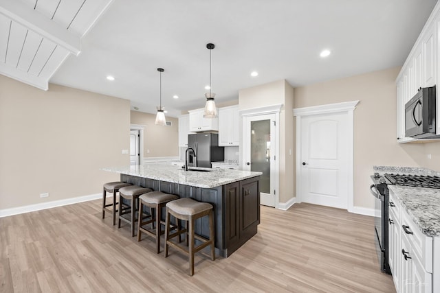 kitchen featuring black appliances, light wood-style flooring, white cabinetry, and recessed lighting