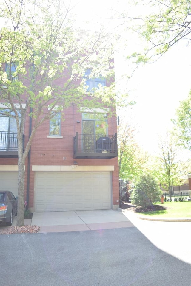 133 S Grove Ave, Elgin, IL 60120 - view of front of house featuring an attached garage, brick siding, and driveway