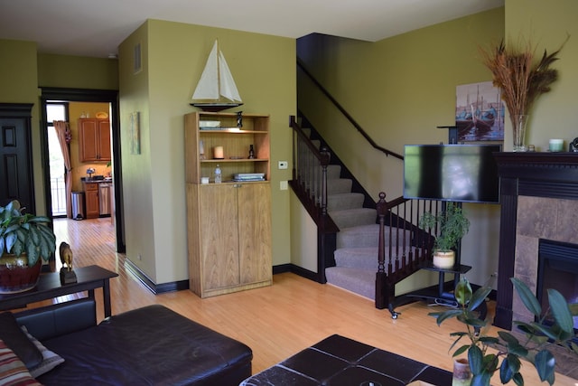 133 S Grove Ave, Elgin, IL 60120 - living area featuring light wood-style flooring, stairway, a fireplace, and baseboards