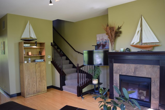 133 S Grove Ave, Elgin, IL 60120 - living room featuring wood finished floors, stairway, a tile fireplace, and baseboards