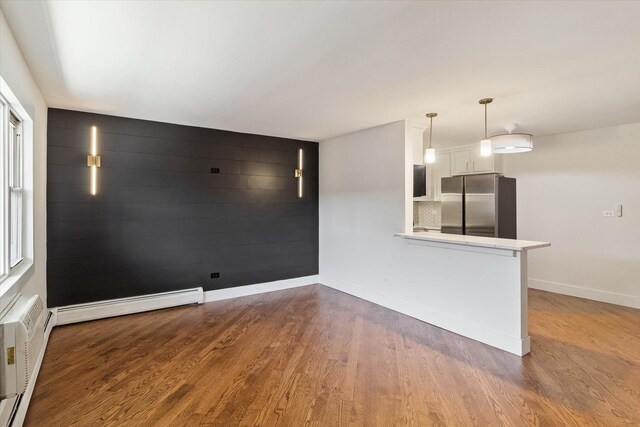 2334 N Harlem Ave Unit 3C, Elmwood Park, IL 60707 - unfurnished living room featuring wood finished floors, a baseboard radiator, baseboards, and baseboard heating