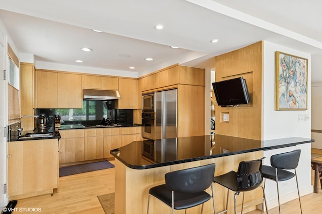 58 W Schiller St, Chicago, IL 60610 - kitchen with stainless steel appliances, light brown cabinets, a sink, a kitchen breakfast bar, and recessed lighting