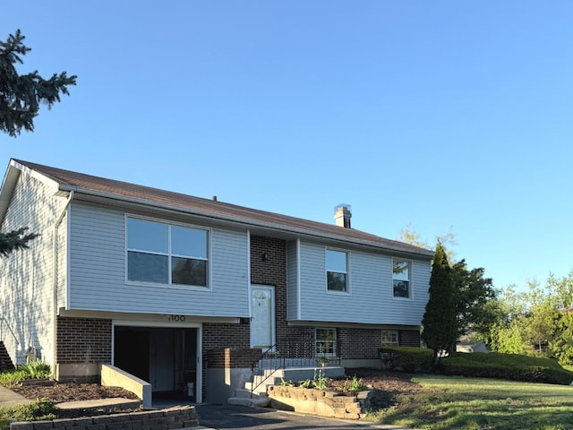 split foyer home featuring brick siding