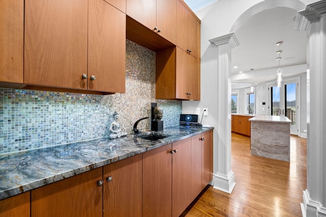 6590 Beech Ln, Libertyville, IL 60048 - kitchen with a sink, decorative columns, light wood-style flooring, dark stone countertops, and tasteful backsplash