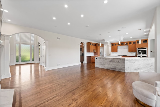 6590 Beech Ln, Libertyville, IL 60048 - living room featuring ornate columns, arched walkways, wood finished floors, recessed lighting, and baseboards
