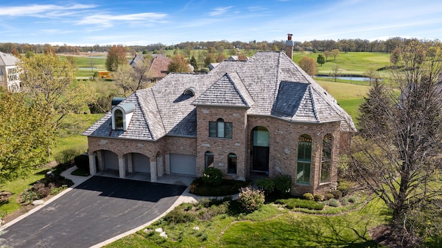 6590 Beech Ln, Libertyville, IL 60048 - french country inspired facade with brick siding, asphalt driveway, a chimney, a water view, and golf course view