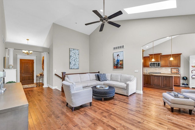 1601 Congressional Way, Champaign, IL 61822 - living room with high vaulted ceiling, light wood-style flooring, a ceiling fan, a skylight, and a chandelier