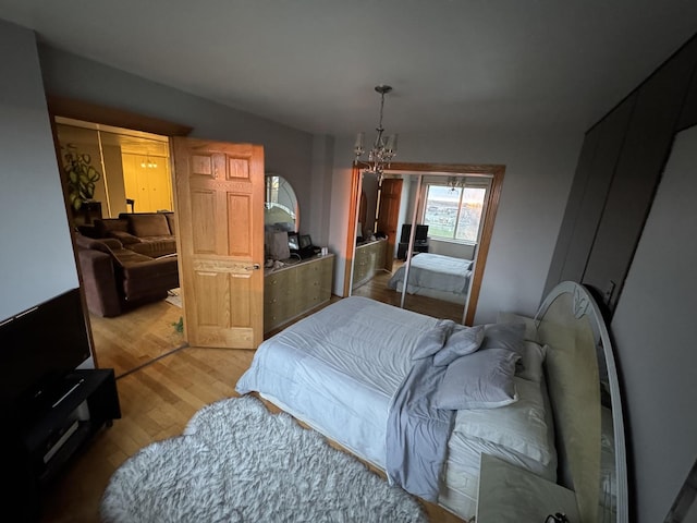 7033 N Kedzie Ave Unit 904, Chicago, IL 60645 - bedroom featuring light wood-style floors, a chandelier, and a closet