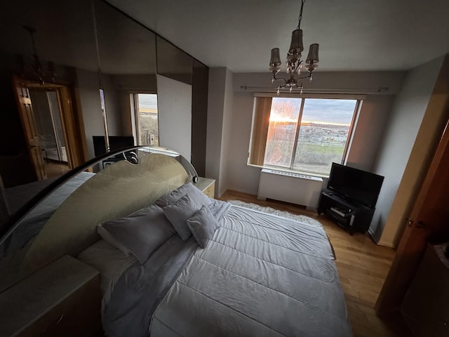 7033 N Kedzie Ave Unit 904, Chicago, IL 60645 - bedroom with a chandelier, light wood-style flooring, multiple windows, and baseboards