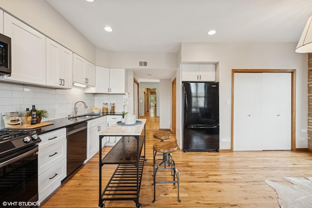 5055 N Sheridan Rd Unit 3N, Chicago, IL 60640 - kitchen with black appliances, decorative backsplash, dark countertops, white cabinets, and recessed lighting