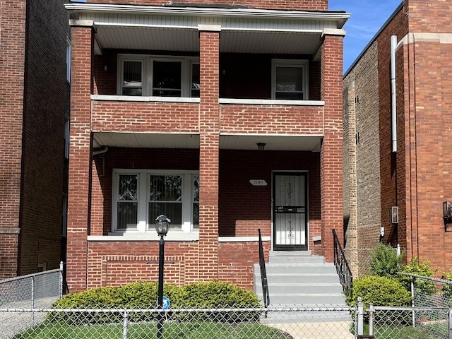 7146 S Calumet Ave, Chicago, IL 60619 - view of front facade with brick siding, fence, and covered porch