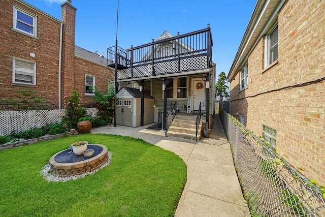 5512 W Wrightwood Ave, Chicago, IL 60639 - back of house with a storage unit, a fire pit, a fenced backyard, a deck, and brick siding