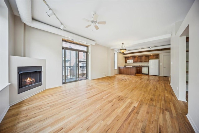 811 S Lytle St Unit 101, Chicago, IL 60607 - unfurnished living room featuring light wood-style floors, a lit fireplace, ceiling fan, track lighting, and baseboards