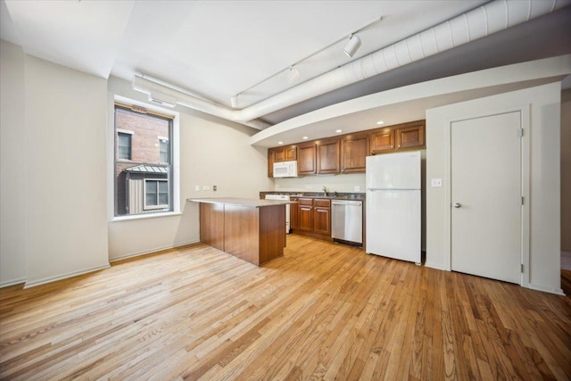 811 S Lytle St Unit 101, Chicago, IL 60607 - kitchen with white appliances, brown cabinetry, a peninsula, light wood-type flooring, and track lighting